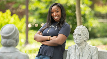 a student standing with the Rosa Parks statues